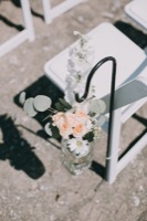 top-down view of flowers in jar on beach aisle
