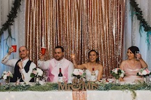head table cheering with gold accent wall