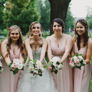 bride and bridesmaids leaning over with bouquets